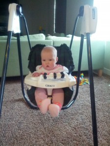 sitting up in the swing - deciding if she likes it or not.